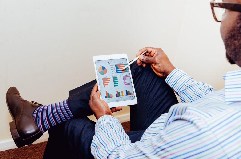 Homem checando o financeiro de uma empresa no seu tablet