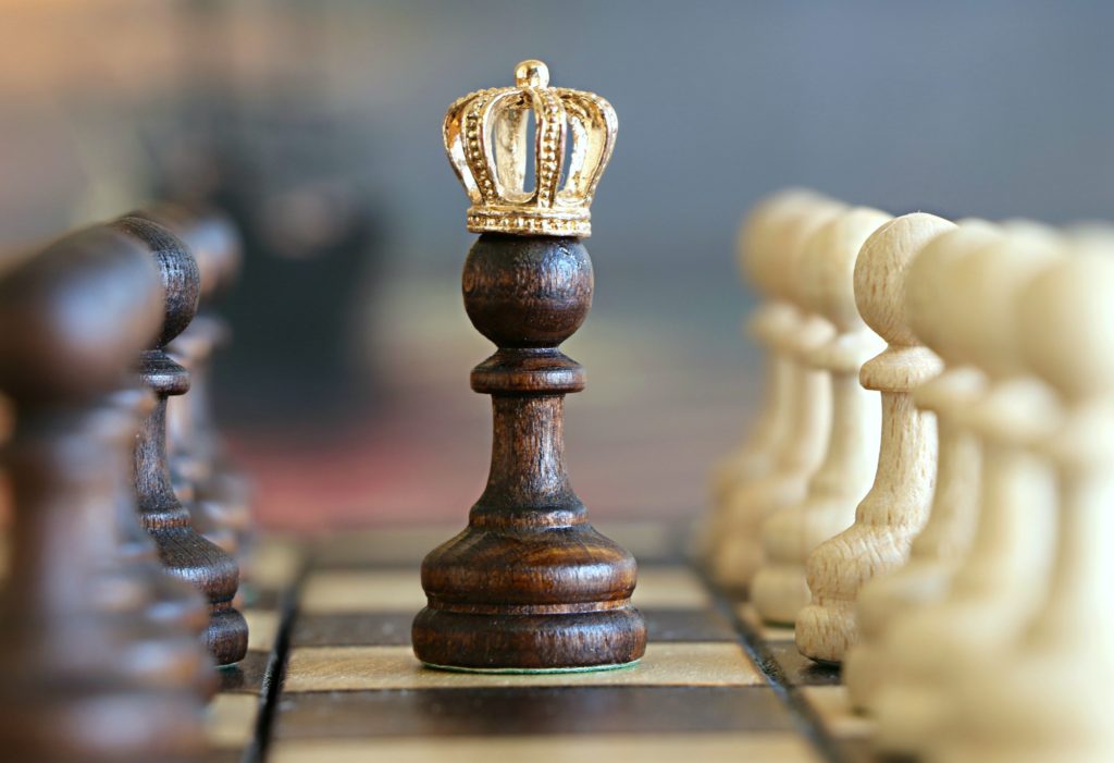 Um jogo de xadrez com uma peça em destaque usando uma coroa, remete às empresas criativas que se destacam no mercado