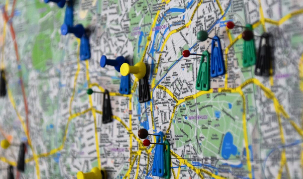 Fotografia de um mapa de uma cidade com taxinhas marcando as regiões mais importantes para o planejamento de como definir o público-alvo