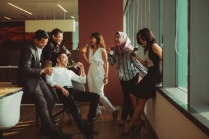 Pessoas diversas conversando e se divertindo no ambiente de trabalho.