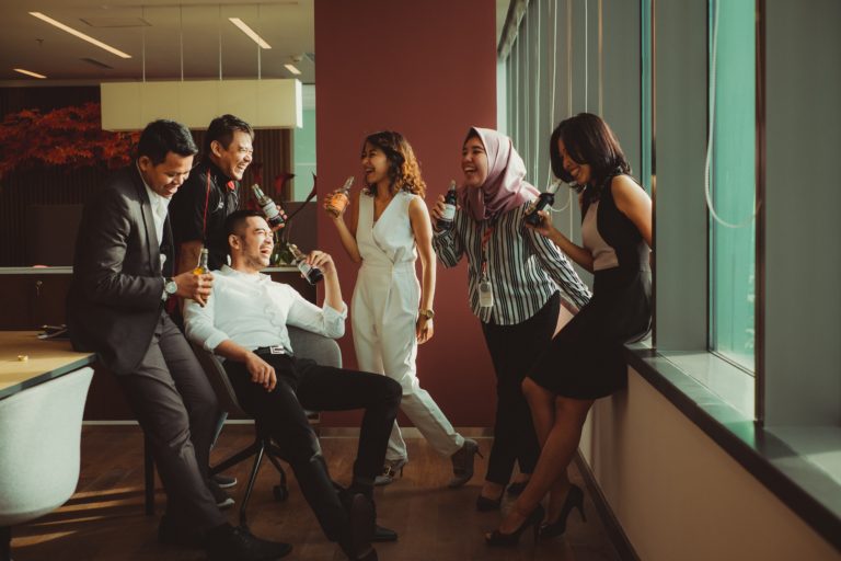 Pessoas diversas conversando e se divertindo no ambiente de trabalho.