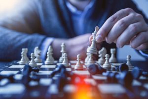fotografia de uma pessoa jogando xadrez como analogia ás estratégias necessárias para vencer o desafio profissional